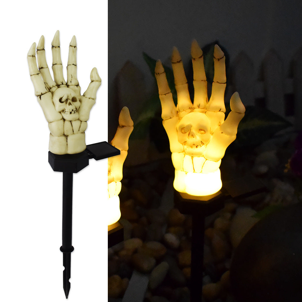 Single skeleton hand stake light in daylight, showing the ground spike and its solar panel