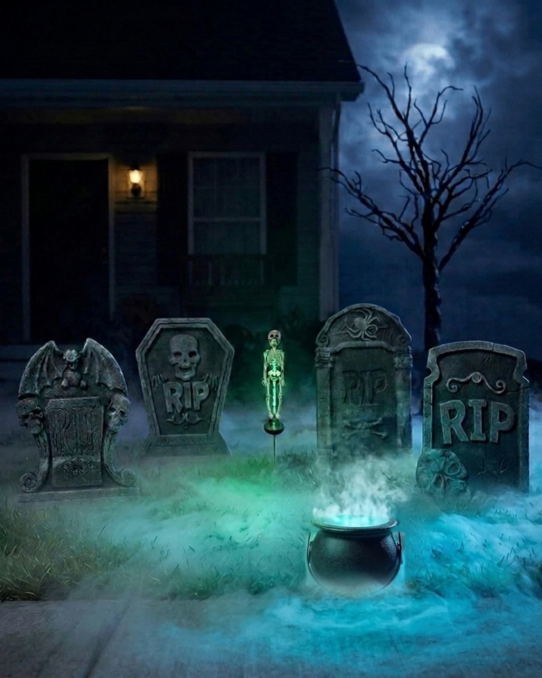 Front-yard graveyard bundle at night: skull lamp, four foam tombstones and a misting cauldron